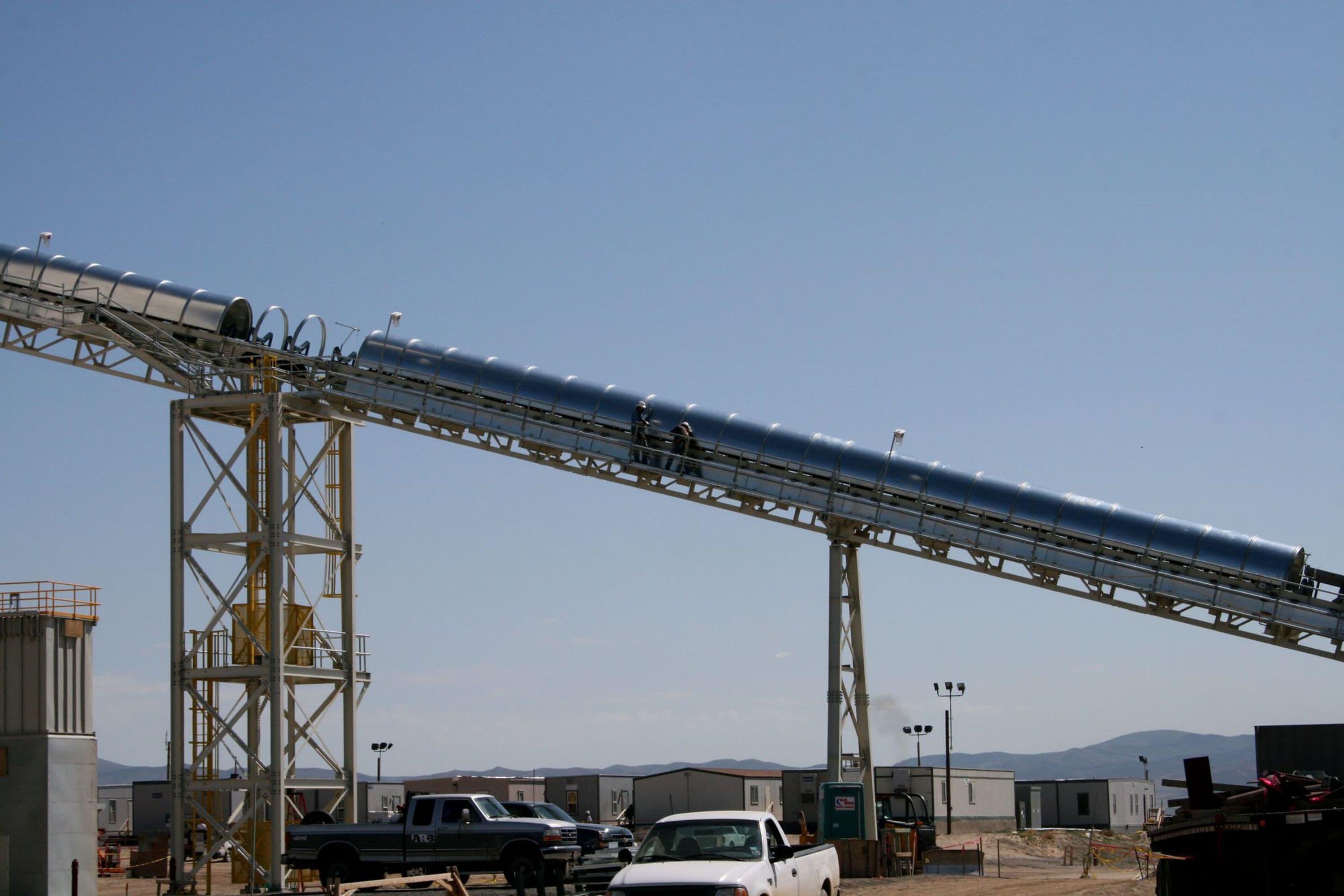 Tractor pulling load under material coal conveyors