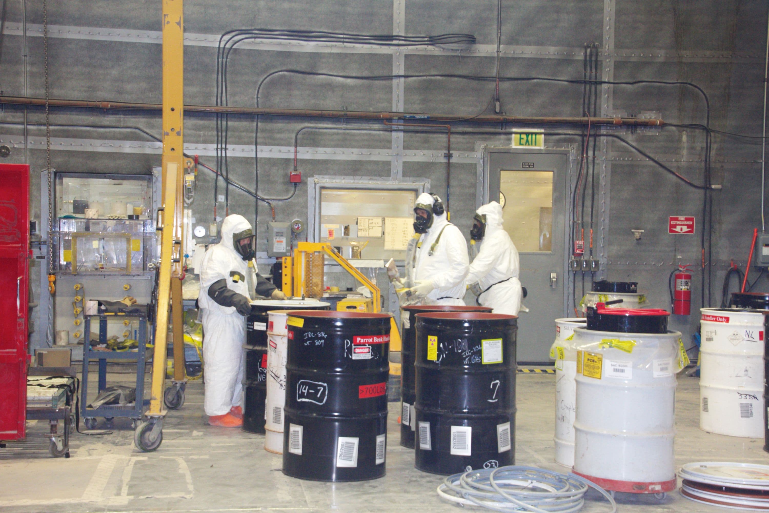 Workers packaging transuranic waste at the Advanced Mixed Waste Treatment Project