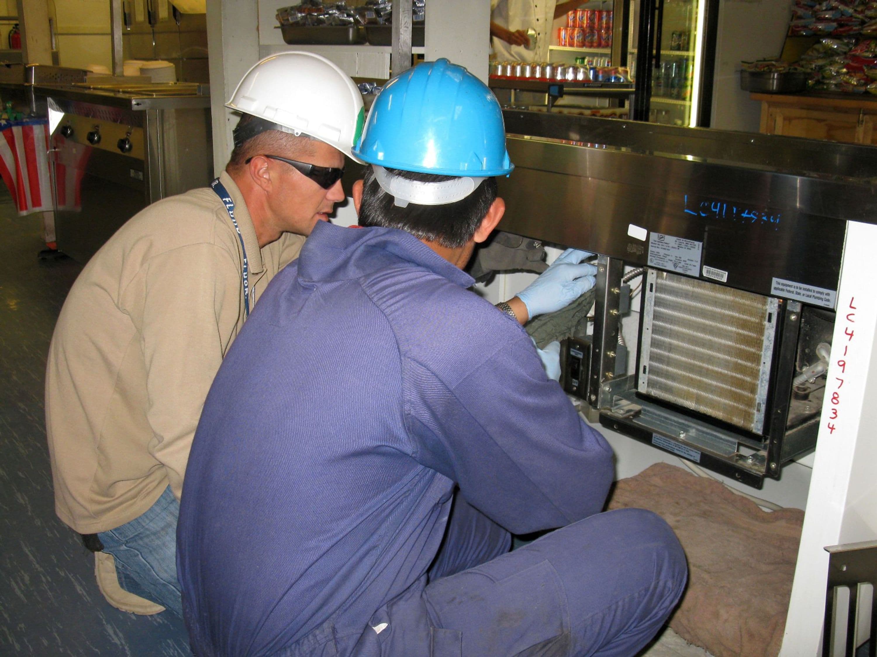 Employees performing preventive maintenance at Camp Lightning