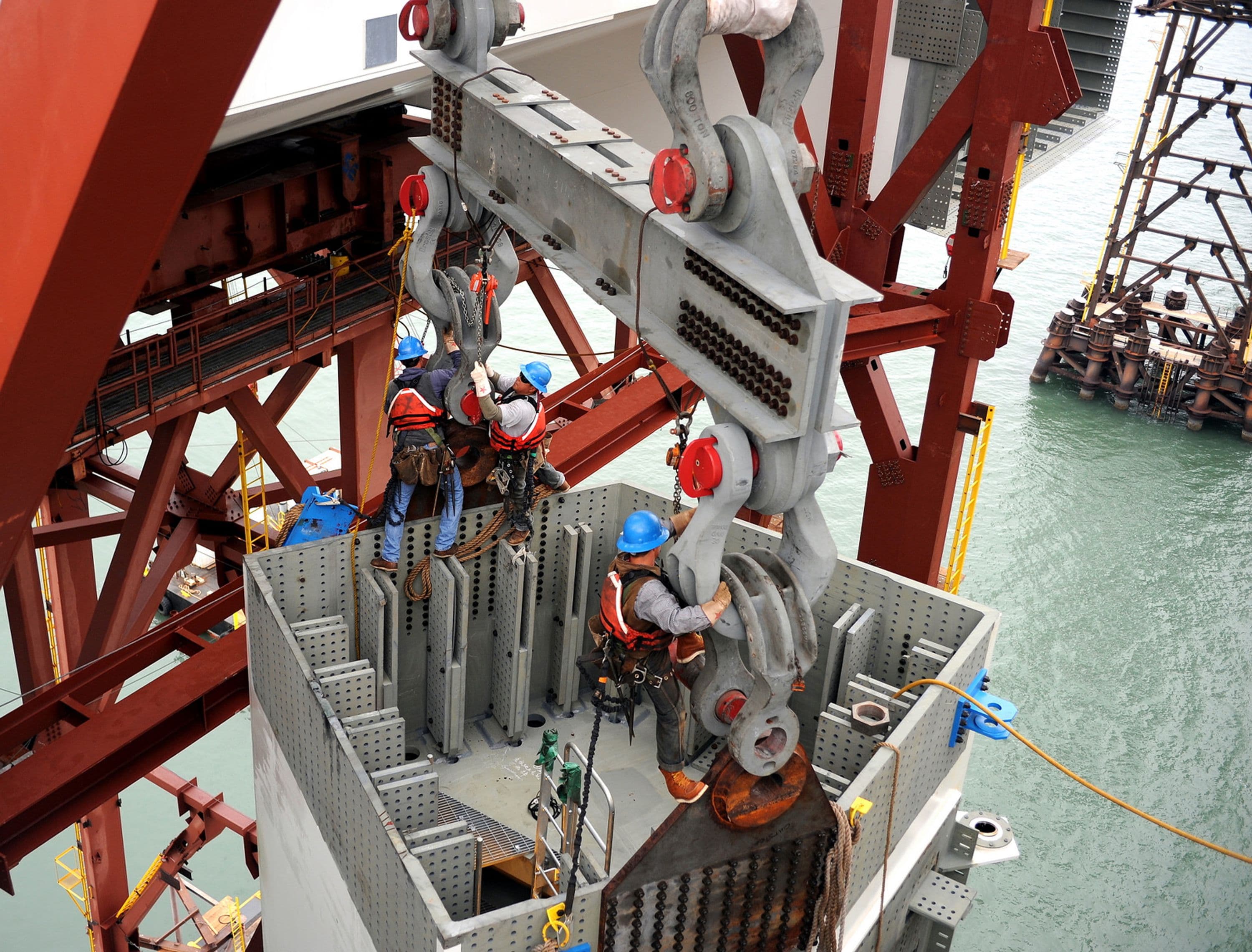 Ironworkers remove lifting shackles from tower shaft