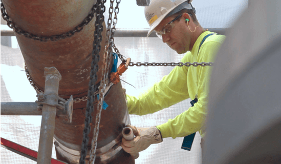 Worker with hard hat working on pipe