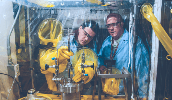 Two researchers working with a glovebox